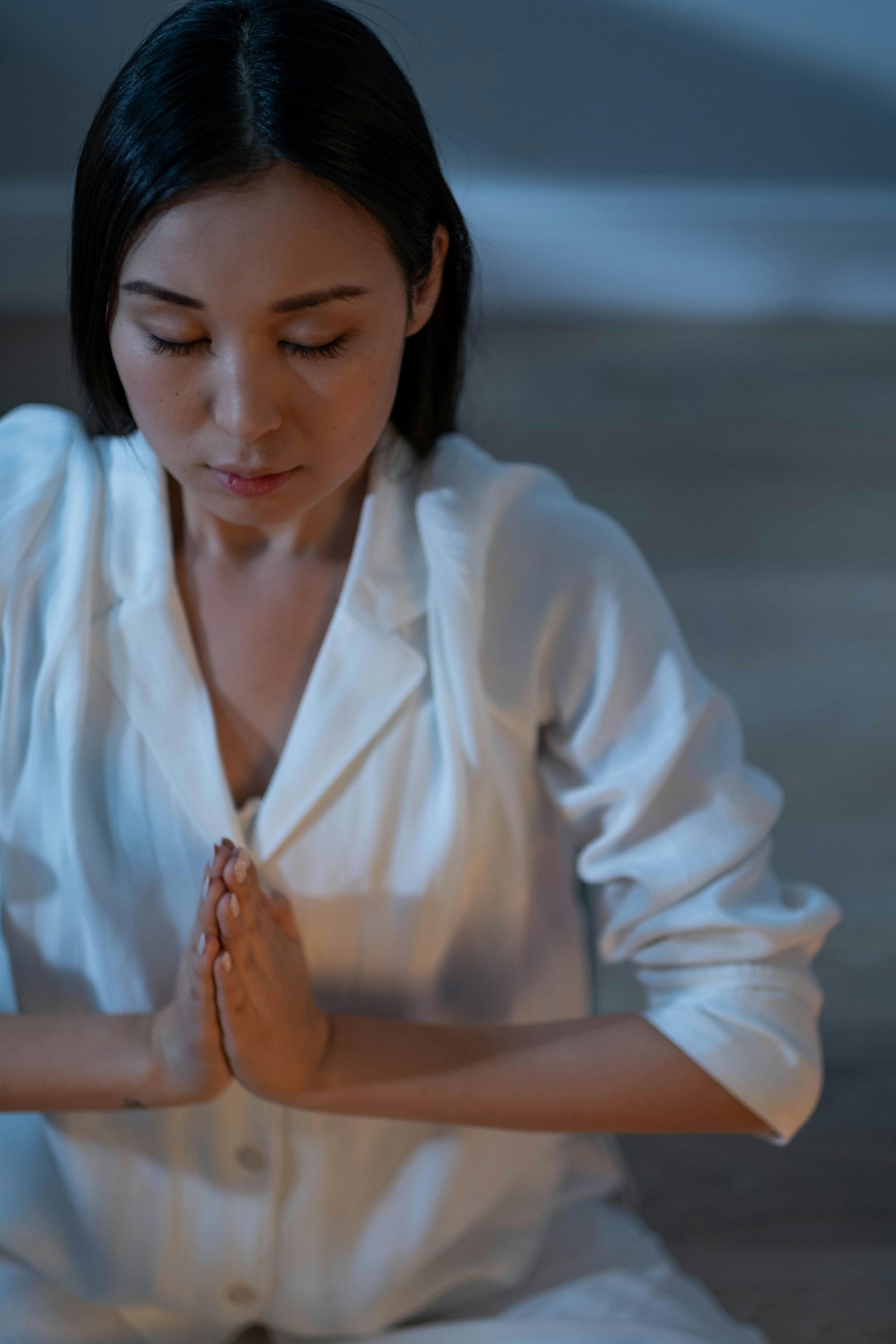 Personne en méditation, mains jointes, lumière douce - illustration apaisante d'une routine bien-être contre le stress et l'anxiété