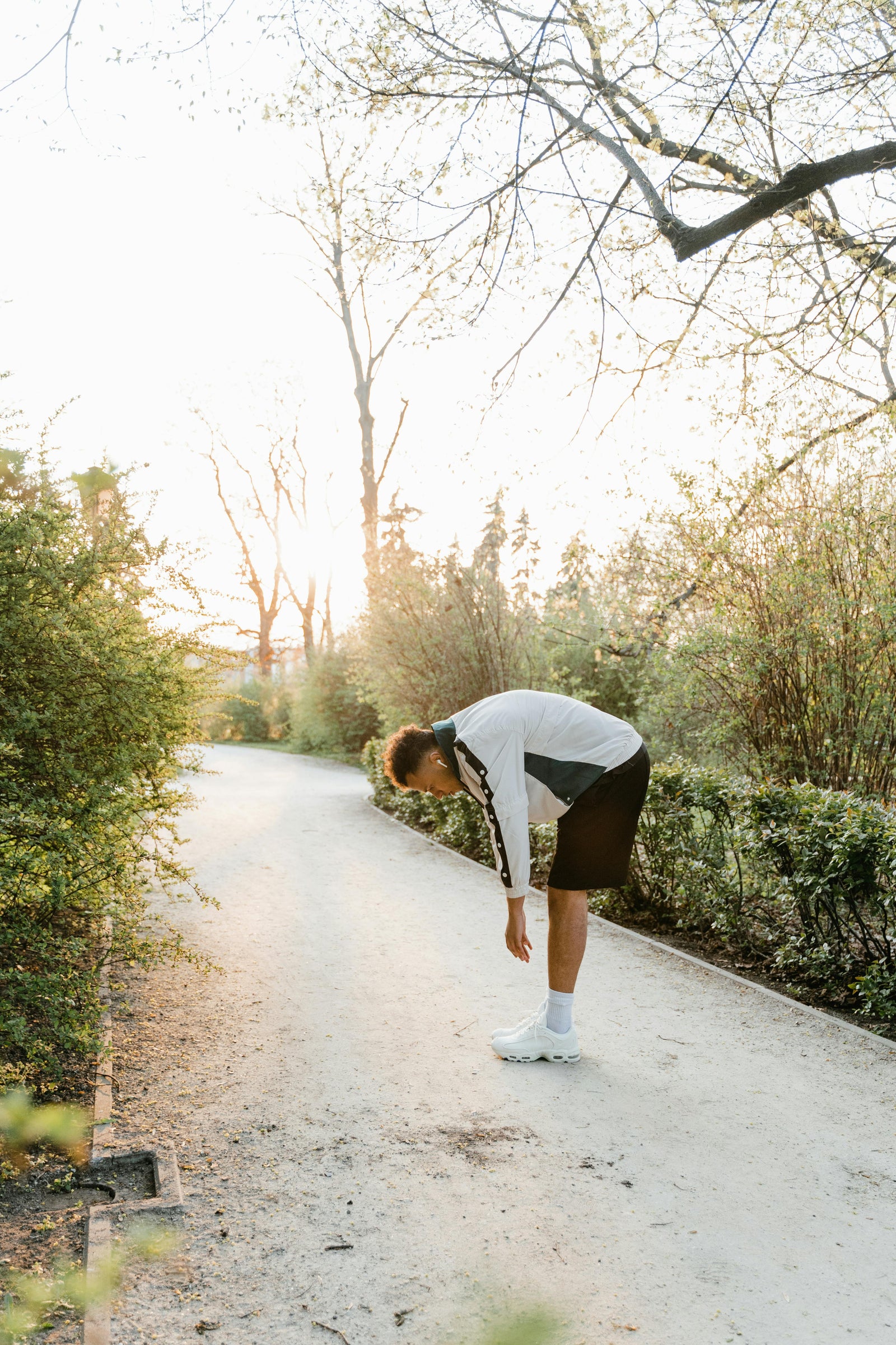 Sportif en étirement dans un parc, lumière naturelle douce - illustration de la récupération sportive et du rôle du CBD