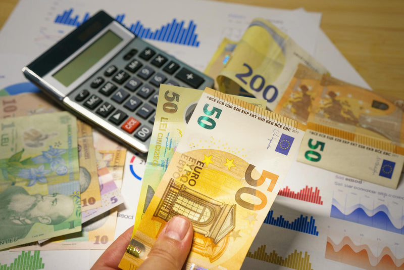 Pièces et billets en euros sur un bureau avec calculatrice - illustration du comparatif des prix du CBD entre France, Suisse, Italie et Espagne en 2026