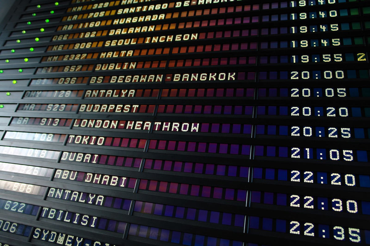 Tableau des départs d'un aéroport affichant des destinations internationales, illustration des règles pour voyager avec du CBD